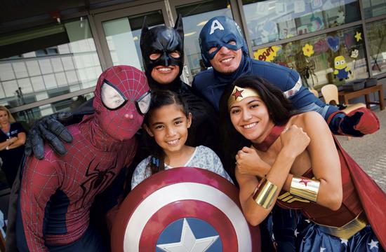 Superheroes met with children on Tuesday after they descended from the roof down from washing windows at Mattel Children’s Hospital Westwood.